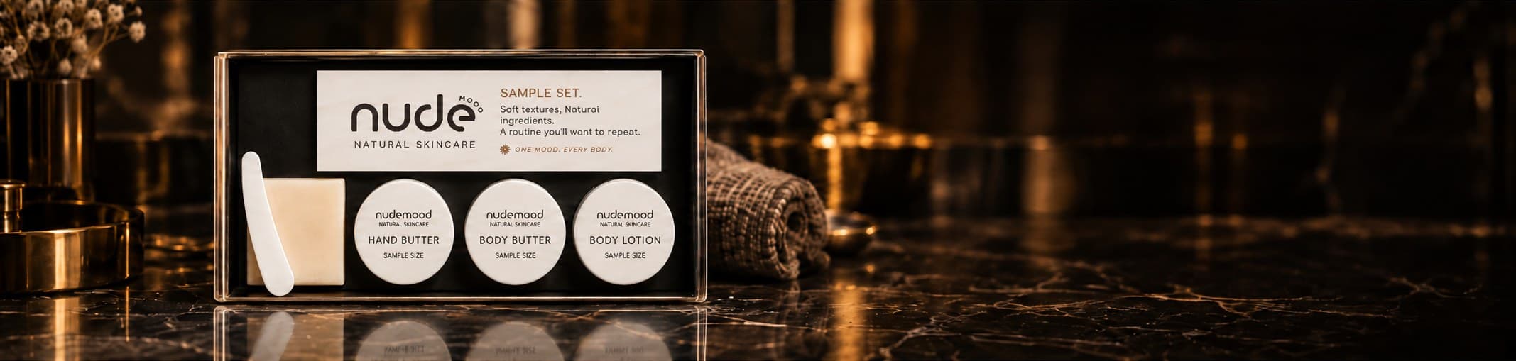The Nude Mood Sample Set — Hand Butter, Body Butter and Body Lotion, styled on dark marble